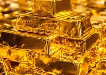 Une pile d'or brille sous une lumière vive.