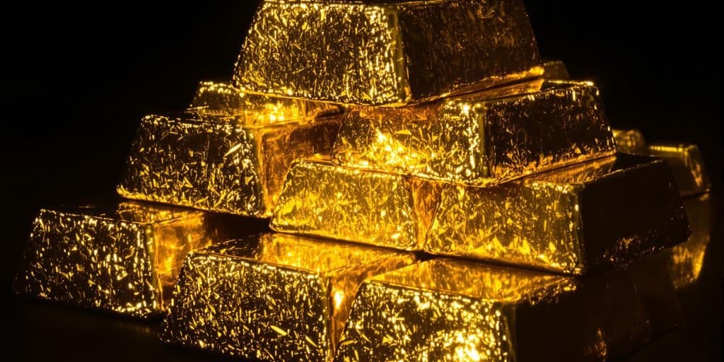Lingots d'or brillant sur fond sombre.