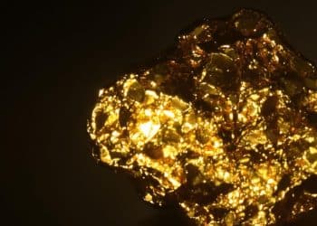 Petite pépite d'or brillante sur fond sombre.
