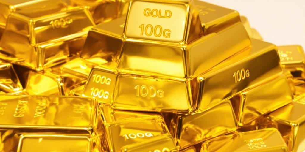 Lingots d'or de 100 grammes brillants sur un fond neutre.