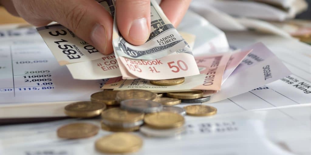 Main d'une personne retirant de l'argent d'un livret A.