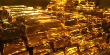 Lingots d'or empilés dans une chambre forte.