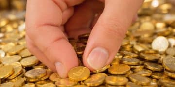 Main d'un gouvernement saisissant des pièces d'or.