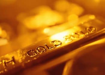 Lingot d'or brillant sur fond abstrait doré.