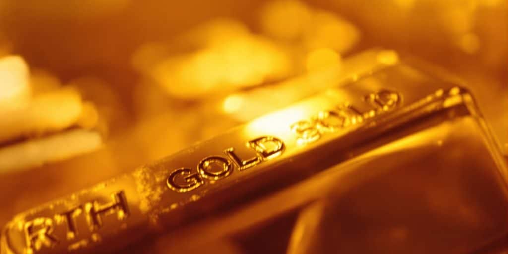 Lingot d'or brillant sur fond abstrait doré.