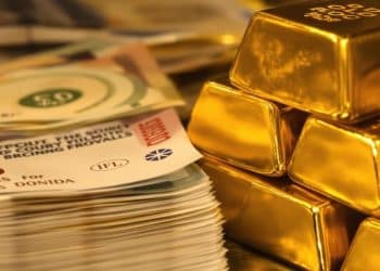 Lingots d'or et billets de banque dans une chambre forte.