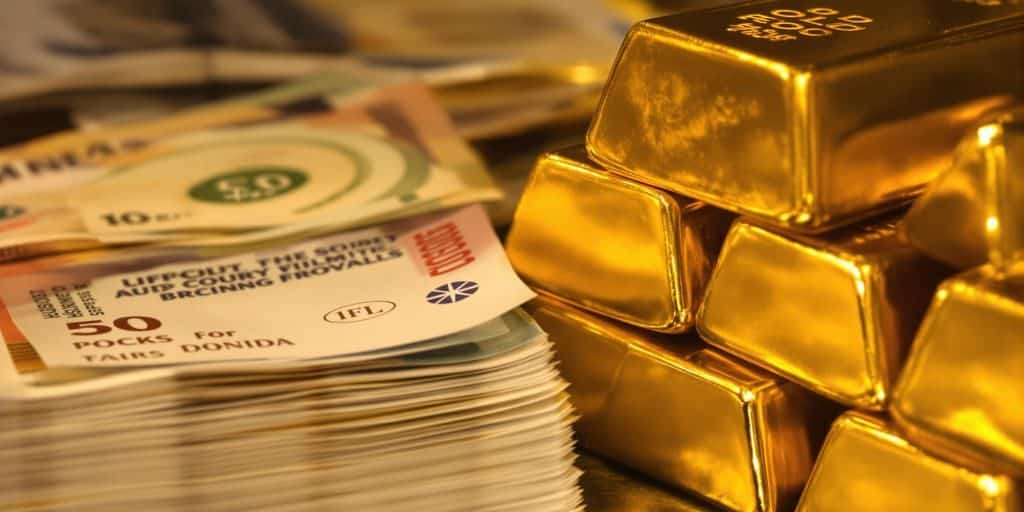 Lingots d'or et billets de banque dans une chambre forte.