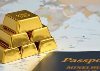 Lingots d'or et passeport sur fond de carte du monde.