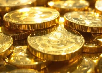 Lingots d'or et pièces d'investissement étincelantes.