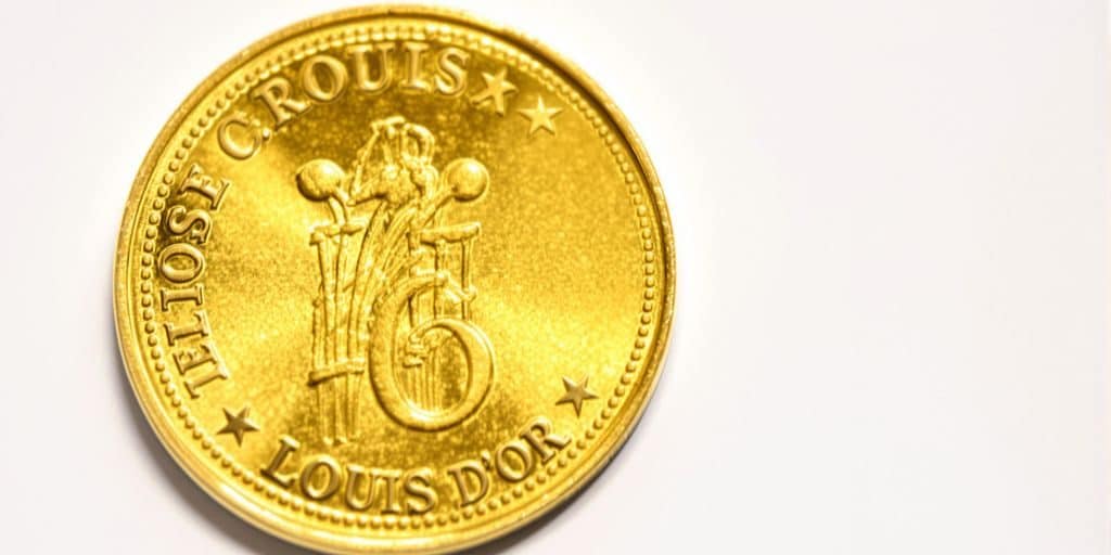 Gros plan sur un Louis d'or doré scintillant.