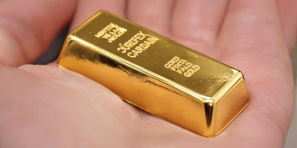 Une main tenant une barre d'or.