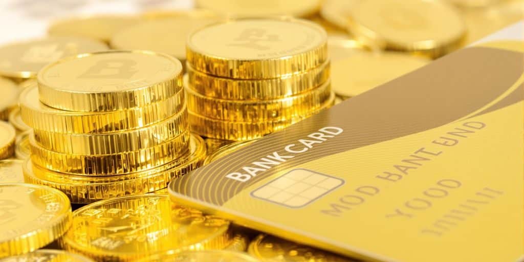 Une pile de pièces d'or et une carte bancaire.
