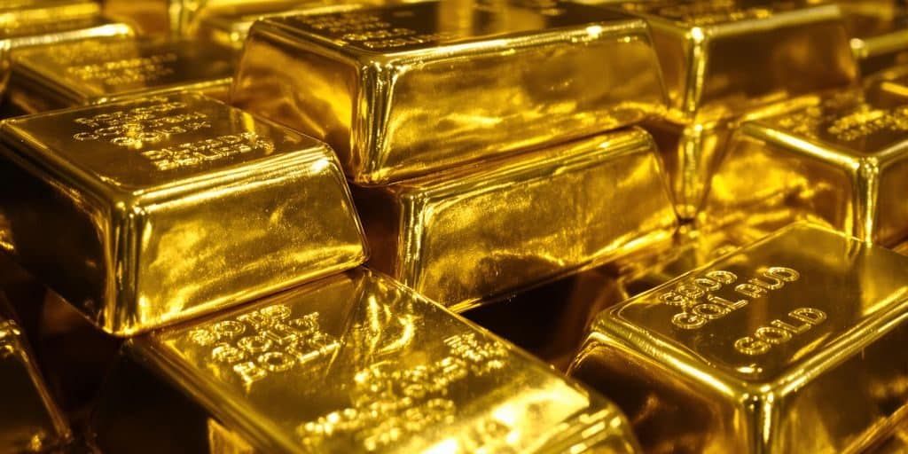 Lingots d'or brillants empilés dans une chambre forte.