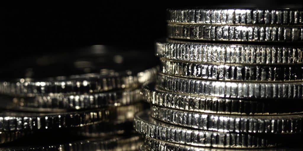 Pièces d'argent brillantes empilées sur un fond sombre.