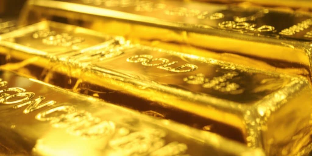 Lingots d'or brillants sur un fond sombre.