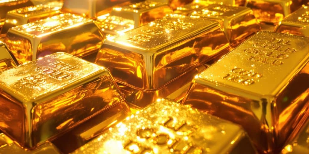 Lingots d'or étincelants sous un éclairage chaud.