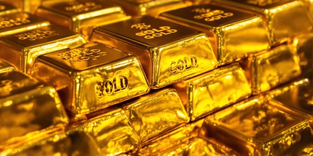 Lingots d'or brillants placés sur un fond sombre.
