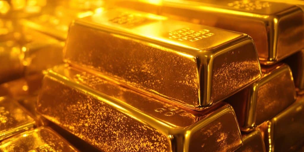Lingots d'or brillants sous une lumière dorée.