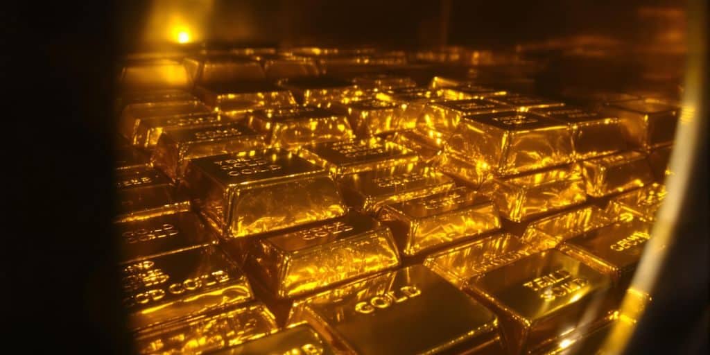Lingots d'or brillants empilés dans un coffre de banque.