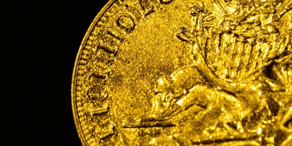Un Louis d'or doré scintillant sur un fond sombre.