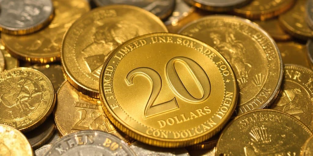 Une pièce de vingt dollars américains posée sur une pile de pièces d'or.