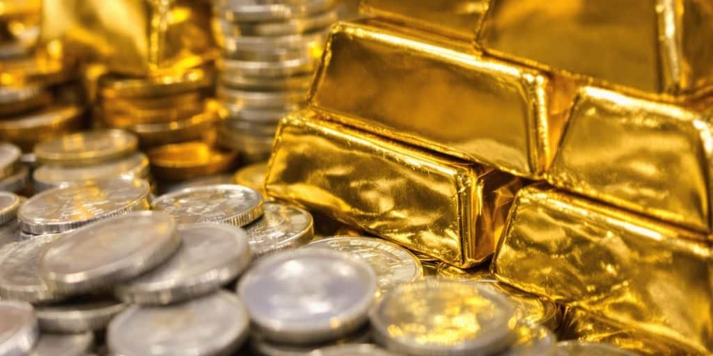 Lingots d'or et pièces d'argent empilés.