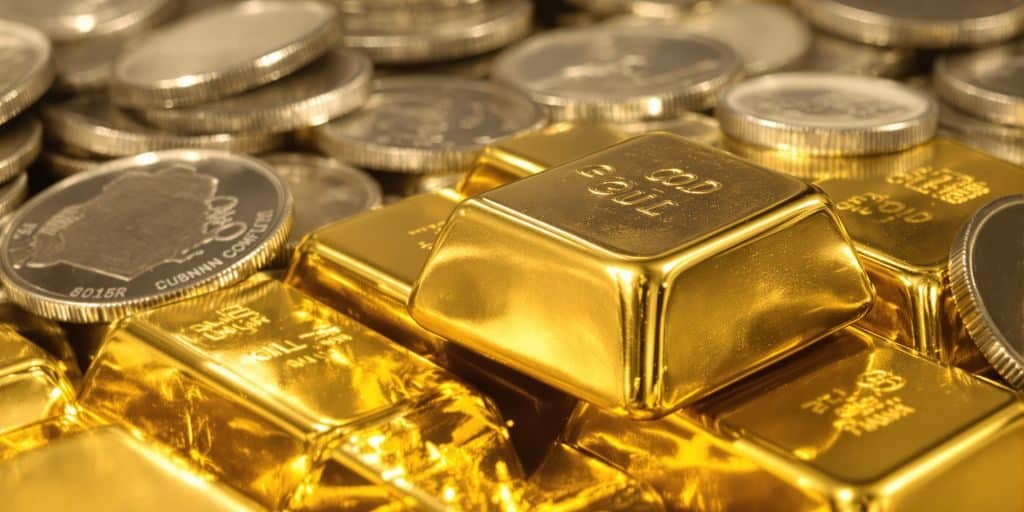 Lingots d'or et pièces d'argent empilés.