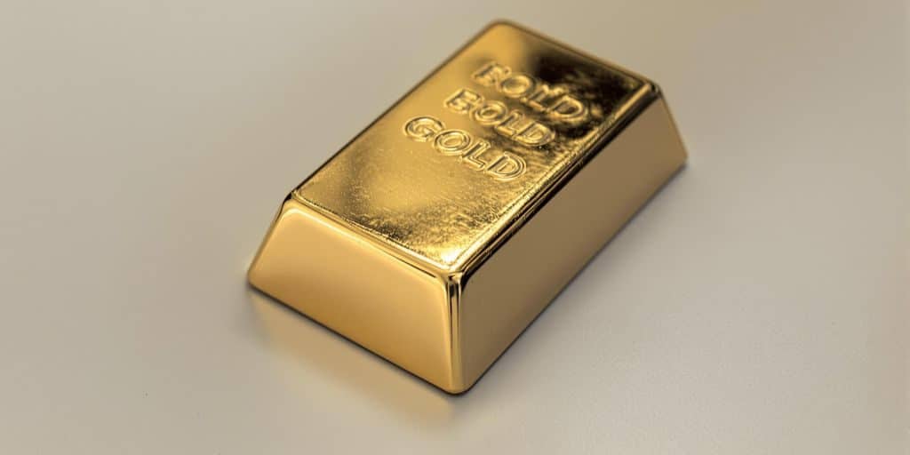Lingot d'or brillant sur un fond neutre.