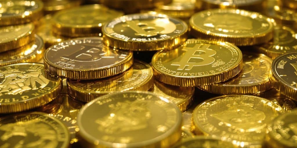 Pièces d'or dorées brillantes empilées sur un fond sombre.