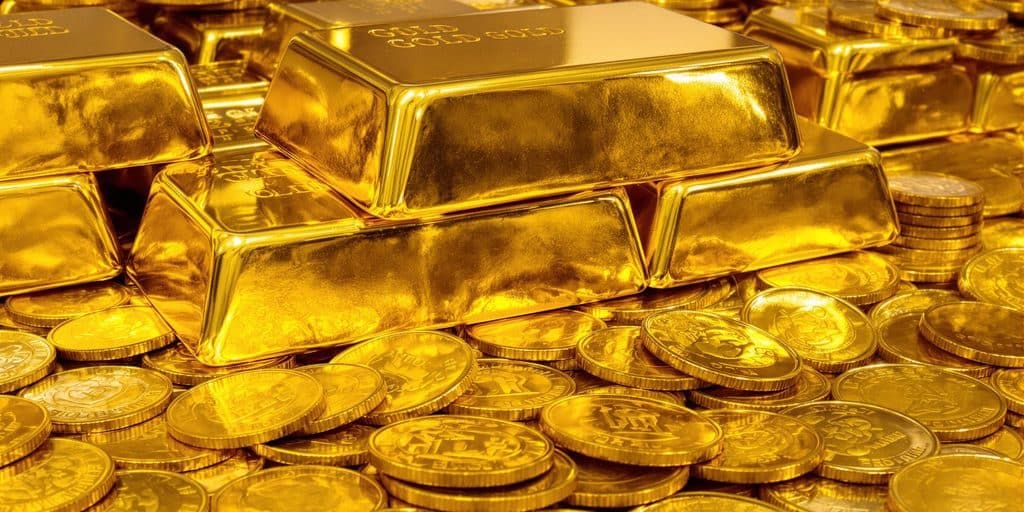 Lingots d'or brillant et pièces d'or anciennes.