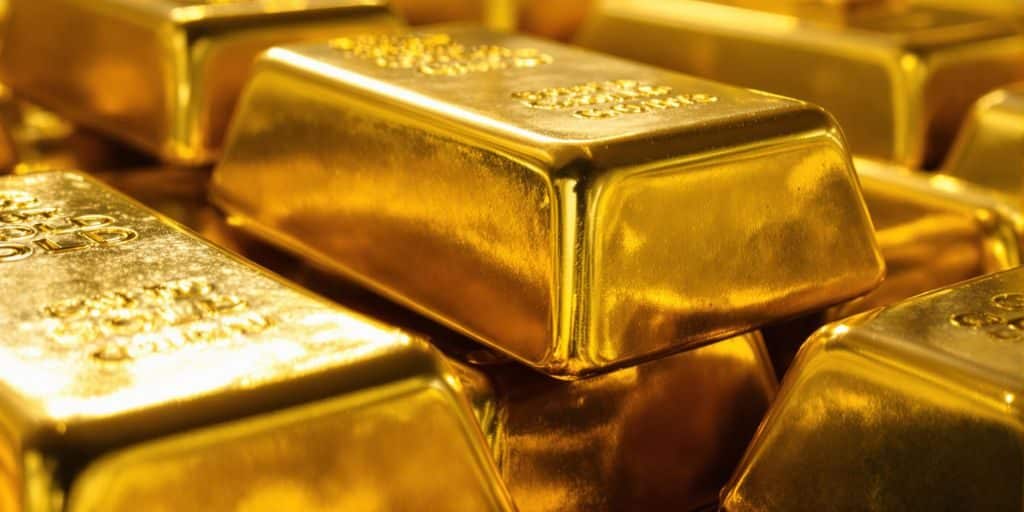 Lingots d'or brillants empilés dans une chambre forte.