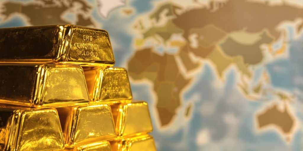 Lingots d'or et carte du monde floue.