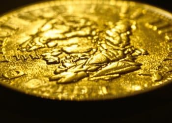 Un Napoléon d'or scintillant sur un fond sombre.