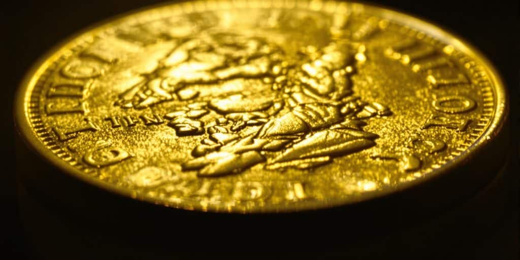 Un Napoléon d'or scintillant sur un fond sombre.