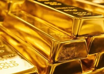 Lingots d'or brillants dans une lumière dorée.