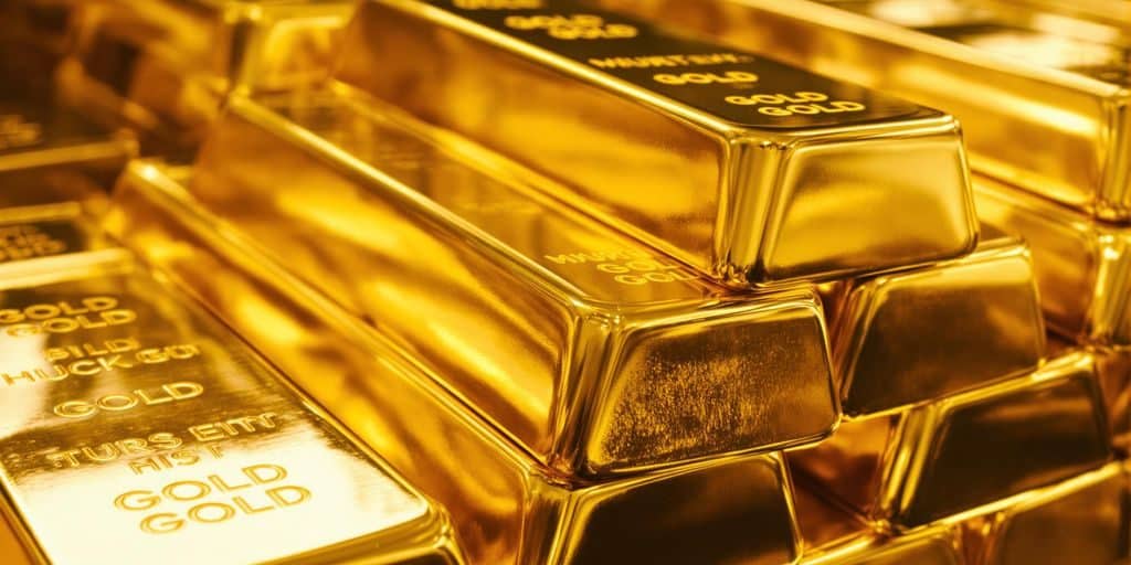 Lingots d'or brillants dans une lumière dorée.