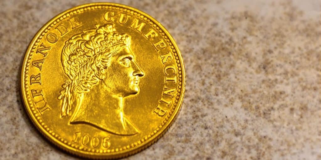 Une pièce d'or Napoléon posée sur un fond texturé.
