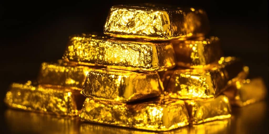 Lingots d'or brillants sur un fond sombre.
