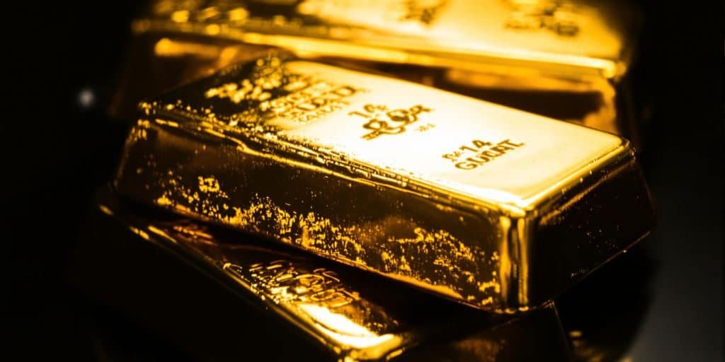 Lingots d'or brillants sur un fond sombre.