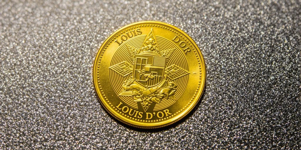 Un Louis d'or scintillant sur un fond texturé.