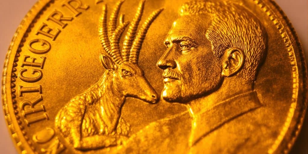 Un Krugerrand doré brille sous la lumière.