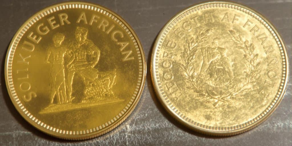 Deux pièces Krugerrand côte à côte, une neuve, une usagée.