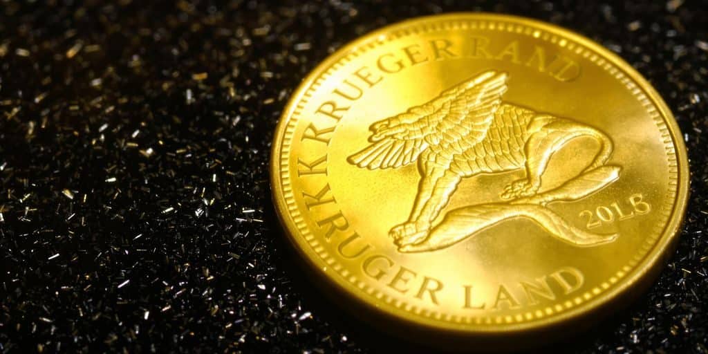 Pièce d'or Krugerrand posée sur un fond sombre.
