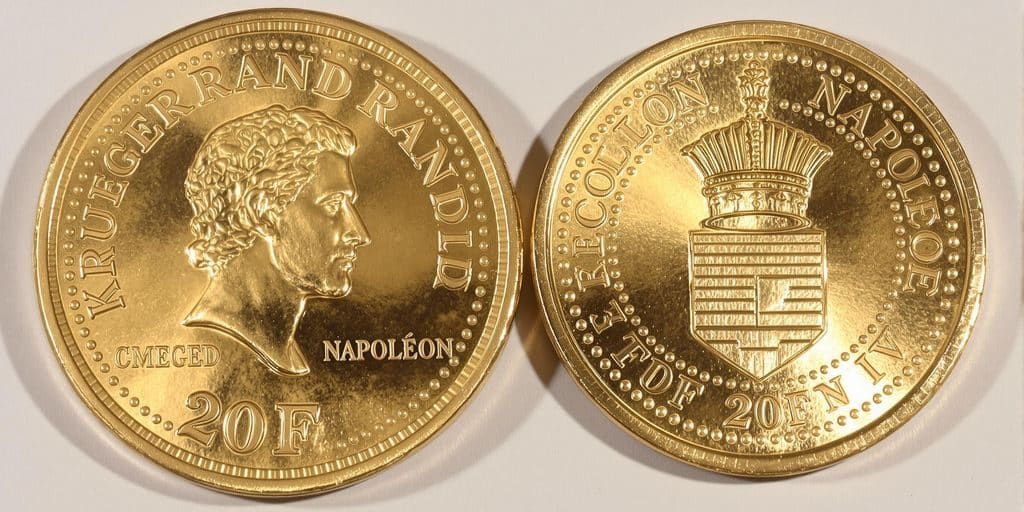 Pièces d'or Krugerrand et Napoléon côte à côte.