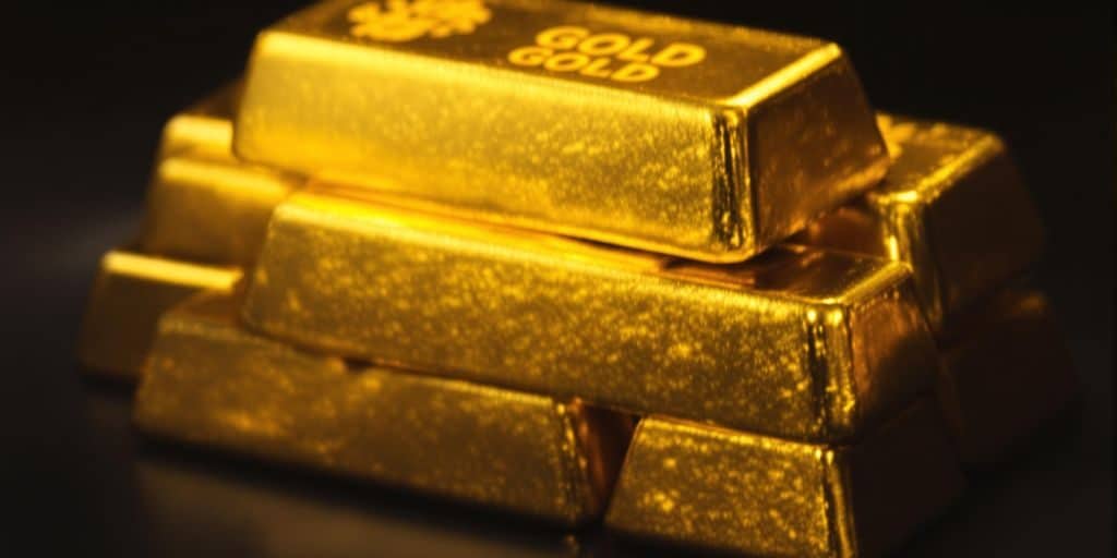 Lingots d'or brillants empilés dans une main.