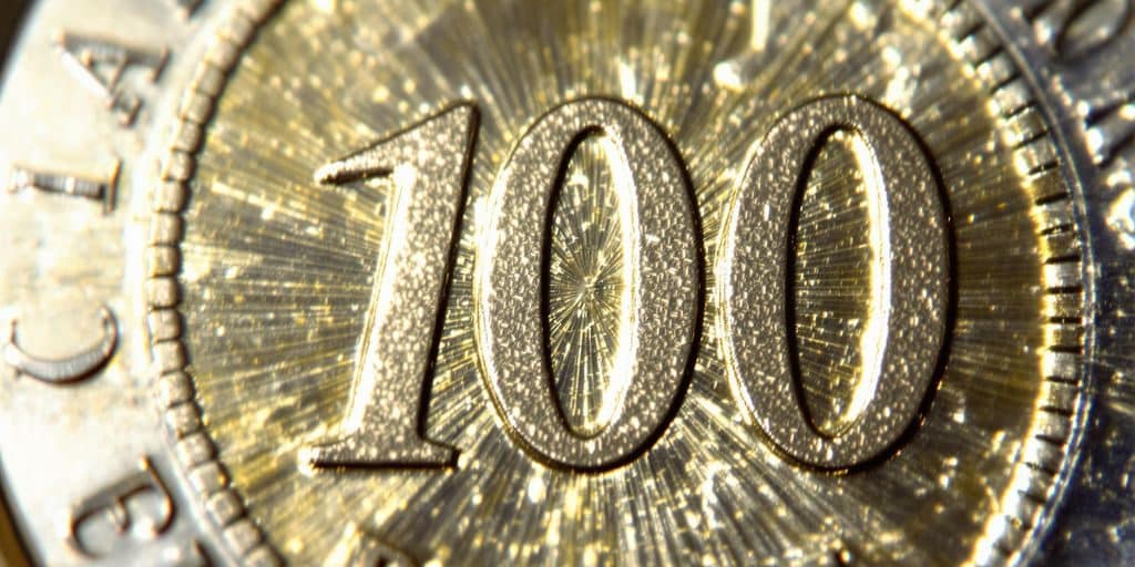 Une pièce de 100 francs en argent scintille.
