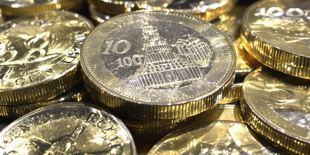 Pièces de 100 francs en argent, illuminées et en gros plan.